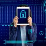 Imagem de uma mulher segurando um tablet com a imagem do cadeado da proteção de dados